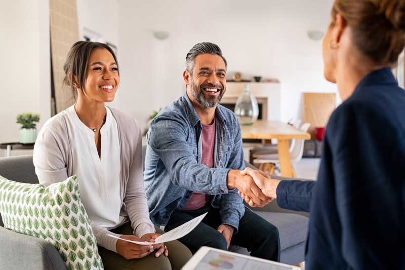 Post a Gig, young couple meeting with a gig workers in their home and shaking their hand